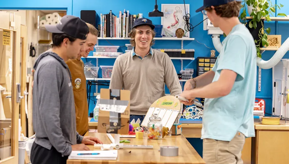 Four UNE business students collaborate on a project in the Makerspace