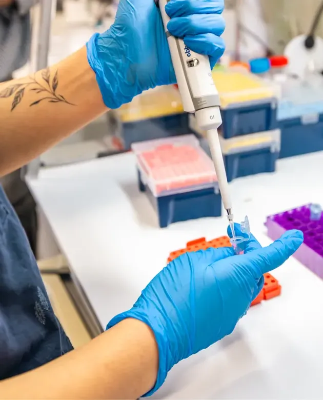 Ruby Motulsky holding a pipet and tube